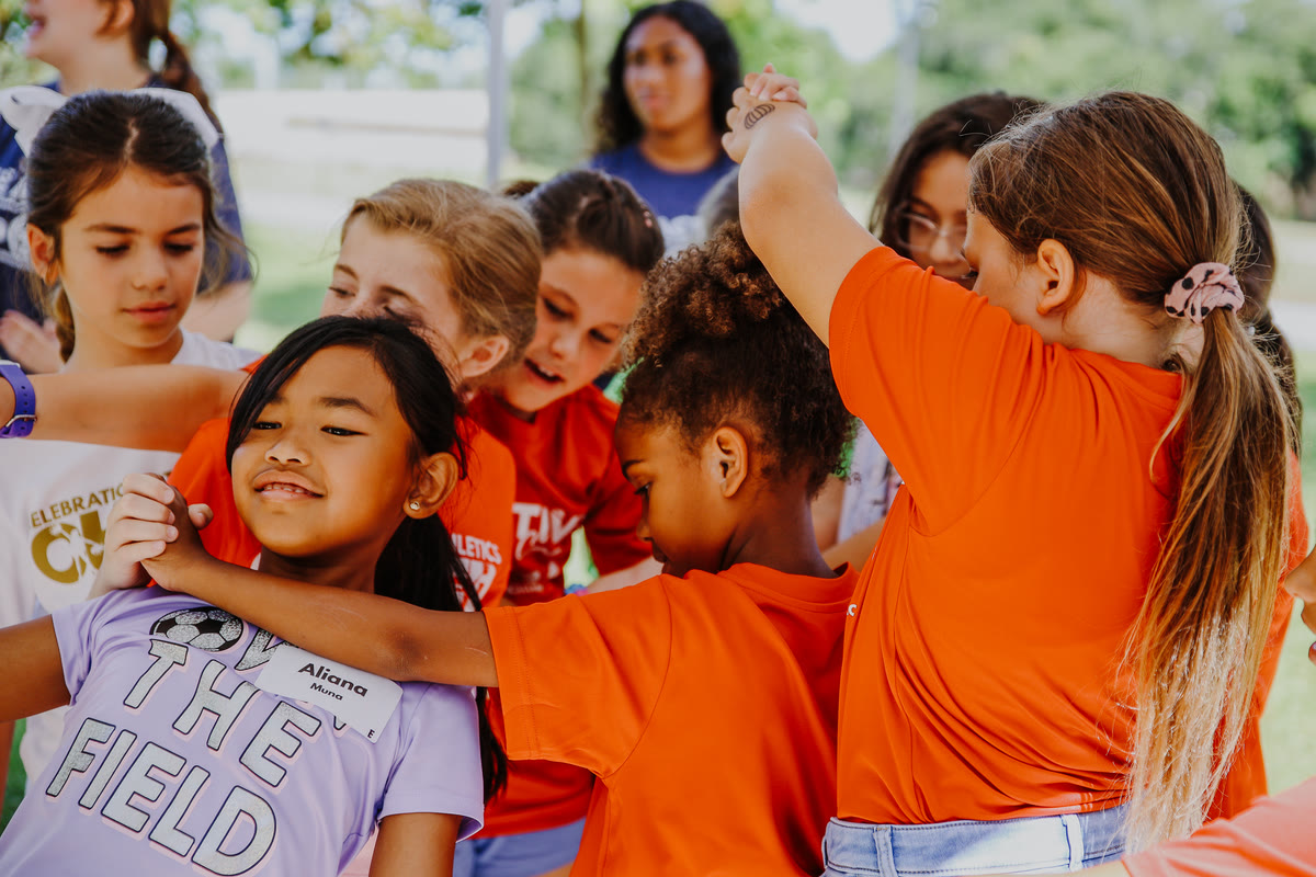 Girls hugging and smiling at a C+A summer camp